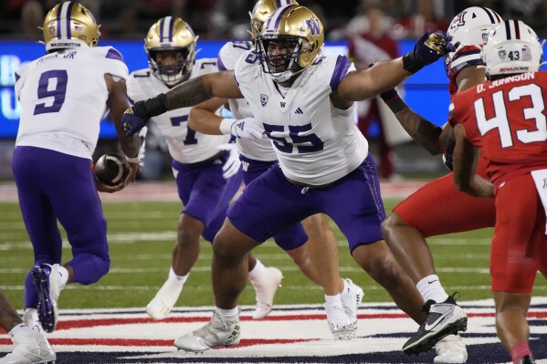 FILE - Washington offensive lineman Troy Fautanu (55) blocks for running back Dillon Johnson (7) who takes a handoff from quarterback Michael Penix Jr. (9) in the first half during an NCAA college football game against Arizona Sept. 30, 2023, in Tucson, Ariz. Fautanu and the Huskies' offensive line paved the way for No. 2 Washington to make the College Football Playoff. They are scheduled to face No. 3 Texas in the Sugar Bowl, Monday, Jan. 1, 2024. (AP Photo/Rick Scuteri)