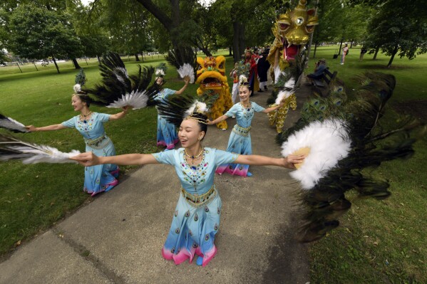 Members of the Tai Ji Men Qigong Academy practice before the Parliament of World Religion Parade of Faiths, Sunday, Aug. 13, 2023, in Chicago. (AP Photo/Paul Beaty)