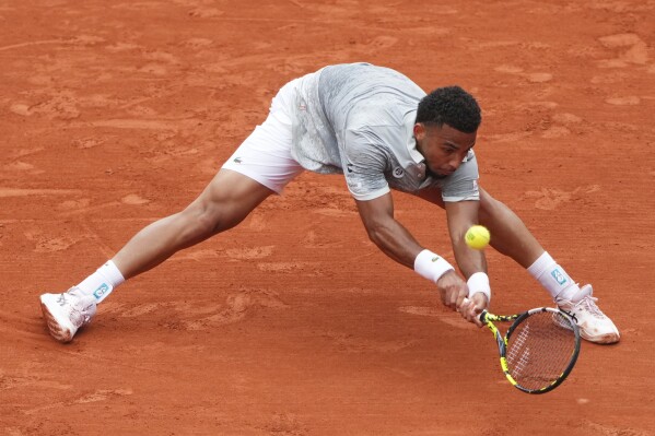 France's Arthur Fils reaches for the ball as he plays Chile's Nicolas Jarry during their first round match of the French Tennis Open, at the Roland-Garros stadium, in Paris, Monday, May 26, 2025. (AP Photo/Lindsey Wasson)