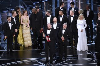 
              Jordan Horowitz, foreground center, and the cast of "La La Land" mistakenly accept the award for best picture at the Oscars on Sunday, Feb. 26, 2017, at the Dolby Theatre in Los Angeles. It was later announced that "Moonlight," was the winner for best picture. (Photo by Chris Pizzello/Invision/AP)
            
