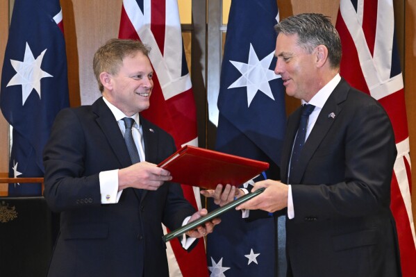 Secretary of State for Defence of the United Kingdom Grant Shapps, left, and Australian Defence Minister Richard Marles exchange a new defence and security cooperation agreement at Parliament House at Parliament House in Canberra, Thursday, March 21, 2024. (Lukas Coch/AAP Image via AP)