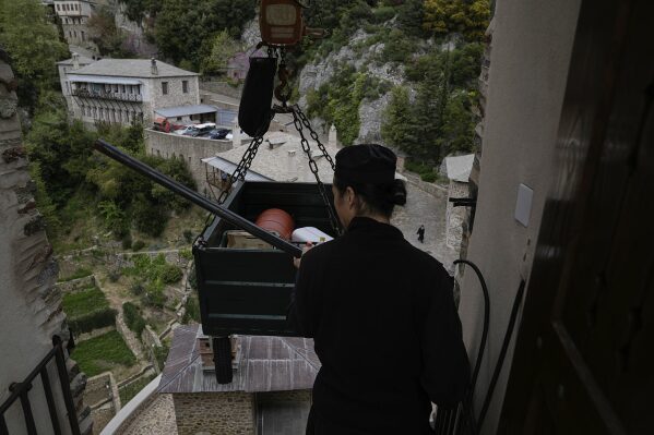 Father Isaiah uses a crane to lift supplies into the Simonopetra, or Simonos Petra Monastery, home of the all-male autonomous community of Agion Oros, or Holy Mountain, on the peninsula of Mount Athos in northern Greece, April 14, 2025. (AP Photo/Thanassis Stavrakis)