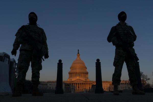 FILE - In this March 8, 2021, file photo, National Guard soldiers stand their posts around the Capitol at sunrise in Washington. Partisan tensions have only gotten worse on Capitol Hill since Pelosi’s defiant act last year, days before the Senate acquitted Trump in his first impeachment trial. Since then, the Capitol has been through the Jan. 6 insurrection, another House impeachment and another Senate acquittal.  (AP Photo/Carolyn Kaster, File)