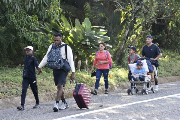 Migrants walk along a highway in Huixtla, Mexico, Monday, Dec. 25, 2023. A caravan of migrants set out north through southern Mexico just days before U.S. Secretary of State Antony Blinken arrives in Mexico City to discuss new agreements to control the surge of migrants seeking entry into the United States. (AP Photo/Edgar H. Clemente)