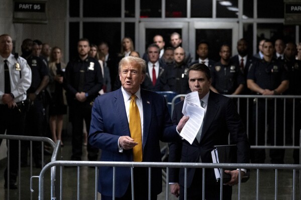 Former President Donald Trump, standing with defense attorney Todd Blanche, speaks after a court session outside his trial at Manhattan criminal court, Tuesday, May 14, 2024, in New York. (AP Photo/Craig Ruttle, Pool)