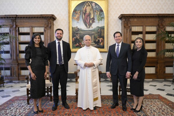 Pope Leo XIV stands for a family photo with Vice President JD Vance, second from left, his wife Usha Vance, Secretary of State Marco Rubio, second from right, and his wife Jeanette Dousdebes Rubio, on the occasion of their meeting at the Vatican, Monday, May 19, 2025. (Vatican Media via AP)
