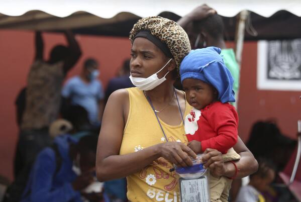 A Haitian migrant woman holds a child in her arms at the Padre Infante shelter, in Monterrey, Mexico, Wednesday, Sept. 22, 2021. (AP Photo/Roberto Martinez)