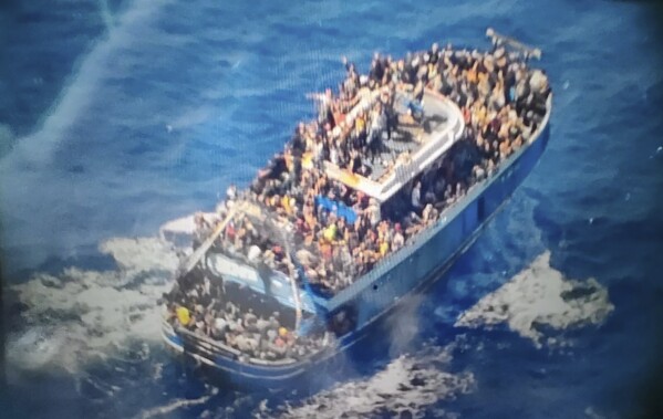 This undated handout image provided by Greece's coast guard on Wednesday, June14, 2023, shows scores of people covering practically every free stretch of deck on a battered fishing boat that later capsized and sank off southern Greece. A fishing boat carrying migrants trying to reach Europe capsized and sank off Greece on Wednesday, authorities said, leaving at least 79 dead and many more missing in one of the worst disasters of its kind this year.(Hellenic Coast Guard via AP)