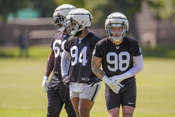 Las Vegas Raiders defensive end Maxx Crosby (98) practices during NFL football training camp at Jack R. Hammett Sports Complex in Costa Mesa, Calif., Wednesday, July 24, 2024. At left and center are Raiders defensive tackles Adam Butler (69) and Christian Wilkins (94). (ĢӰԺ Photo/Damian Dovarganes)