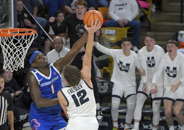 El delantero de Boise State, O'Mar Stanley (1), hace falta al guardia del estado de Utah, Mason Falslev (12), durante la segunda mitad de un partido de baloncesto universitario de la NCAA el sábado 10 de febrero de 2024 en Logan, Utah.  (Eli Lucero/The Herald Journal vía AP)