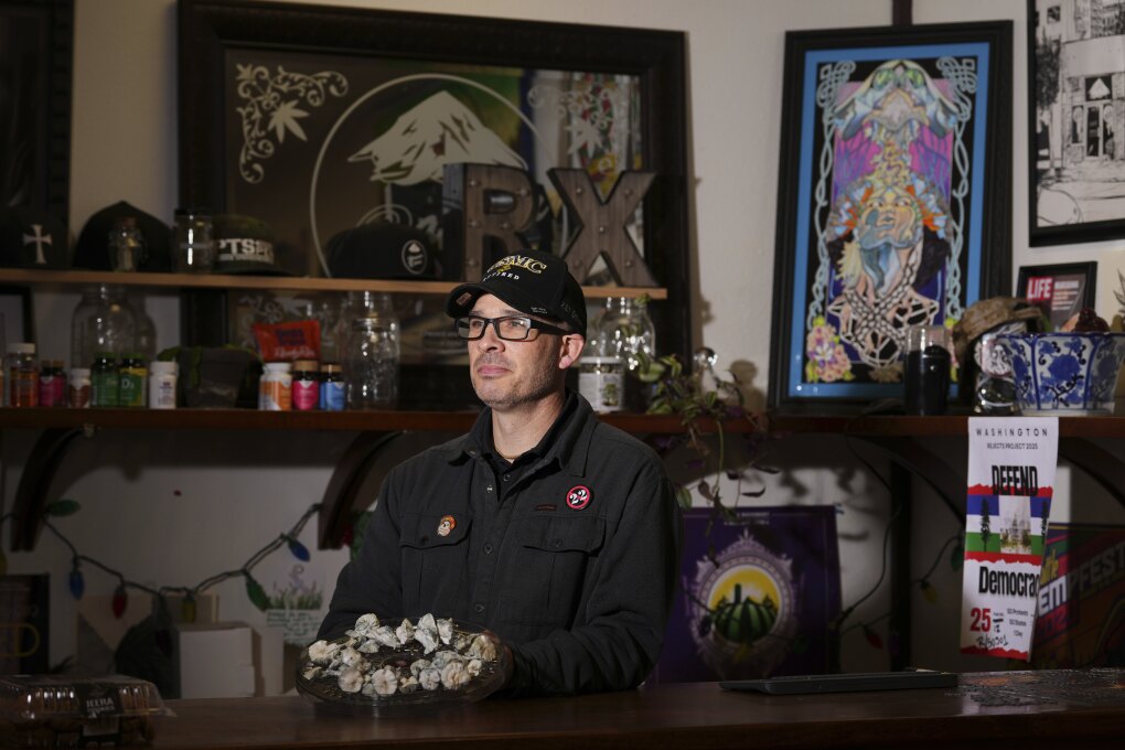 Marine Corps combat veteran Matt Metzger poses for a portrait with a plate of mushrooms that he grows himself for microdosing psilocybin, Wednesday, March 26, 2025, in Olympia, Wash. (AP Photo/Lindsey Wasson)