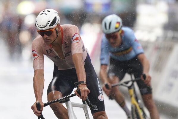 Netherland's Mathieu van der Poel, left, pedals during the Men's Elite Road Race on day four of the 2023 UCI Cycling World Championships in Glasgow, Scotland, Sunday Aug. 6, 2023. (Tim Goode/PA via AP)