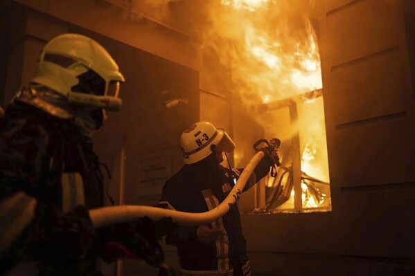 In this image provided by the Ukrainian Emergency Service, firefighters work to extinguish a fire after a Russian attack in Odesa, Ukraine, Thursday, July 20, 2023. (Pavlo Petrov/Ukrainian Emergency Service via AP)