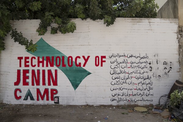 A mural that reads in Arabic "They are bombing but you are not destroyed, let them be violent and you will be more violent," in the occupied West Bank's Jenin refugee camp, Jenin, Sunday, Aug. 13, 2023. (AP Photo/Nasser Nasser)
