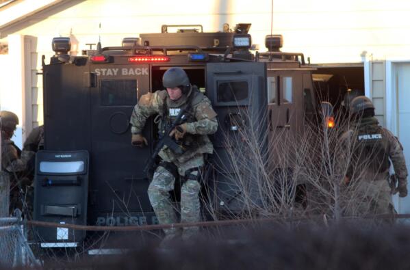 Waterloo police tactical officers arrive at the scene of a standoff in in Waterloo, Iowa, on Wednesday, Jan. 19, 2022. A Wisconsin man accused of killing his girlfriend and trying to kill his teenage daughter in a double shooting in Milwaukee has been arrested following an hourslong standoff in northeastern Iowa. (Jeff Reinitz/The Courier via AP)