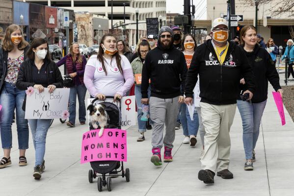 People march to the post office in downtown Boise, Idaho to mail letters to Idaho Governor Brad Little as part of a protest over Senate Bill 1309 on Saturday, March, 19, 2022.  (Sarah A. Miller/Idaho Statesman via AP)