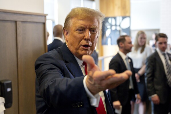 Republican presidential candidate former President Donald Trump gestures as he visits a Chick-fil-A eatery, Wednesday, April 10, 2024, in Atlanta. (AP Photo/Jason Allen)