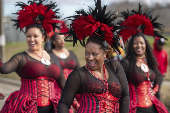 Member of the Mystic Krewe of Femme Fatale have fun with the crowd as the Krewe of Nefertiti rolls along Lake Forest Blvd. in New Orleans East , Sunday, Jan. 28, 2024. (David Grunfeld/The Times-Picayune/The New Orleans Advocate via AP)