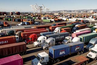 FILE - Trucks line up to enter a Port of Oakland shipping terminal on Wednesday, Nov. 10, 2021, in Oakland, Calif. The U.S. economy grew at a 2.3% rate in the third quarter, the Commerce Department said Wednesday, Dec. 22. But prospects for a solid rebound going forward are being clouded by rising worries about the rapid spread of the new omicron virus. (AP Photo/Noah Berger, File)