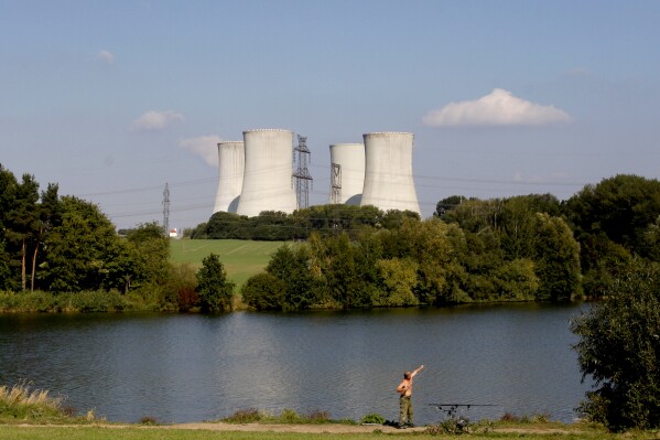 A man fishes with the towering Dukovany nuclear power plant in the background, in Dukovany, Czech Republic, Sept. 27, 2011. (AP Photo/Petr David Josek, File)