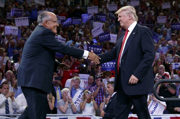 FILE — Republican presidential candidate Donald Trump, right, arrives at a campaign rally after being introduced by former New York Mayor Rudy Giuliani, left, at the University of North Carolina Wilmington, Aug. 9, 2016, in Wilmington, N.C. Giuliani, once warmly regarded as "America's Mayor" in the wake of the 9/11 attacks, and who first rose to prominence as a federal prosecutor going after mobsters with a then-novel approach to racketeering cases, has seen his reputation tumble and his liberty threatened in defense of Donald Trump's bogus election fraud claims. (AP Photo/Evan Vucci, File)