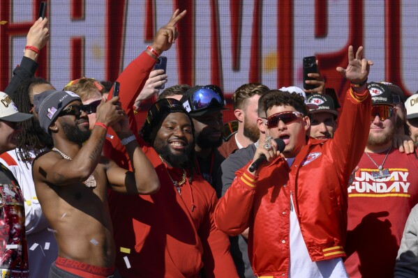 Kansas City Chiefs quarterback Patrick Mahomes, right, tells the crowd the Chiefs want to win another Super Bowl next season, during their victory rally in Kansas City, Mo., Wednesday, Feb. 14, 2024. The Chiefs defeated the San Francisco 49ers Sunday in the NFL Super Bowl 58 football game. (AP Photo/Reed Hoffmann)