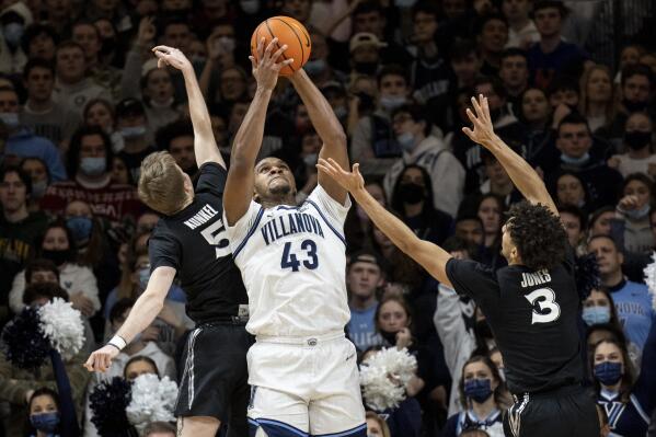 Villanova forward Eric Dixon (43) grabs a rebound away from Xavier's Adam Kunkel (5) and Colby Jones (3) during the first half of an NCAA college basketball game Tuesday, Dec. 21, 2021, in Villanova, Pa. (AP Photo/Laurence Kesterson)