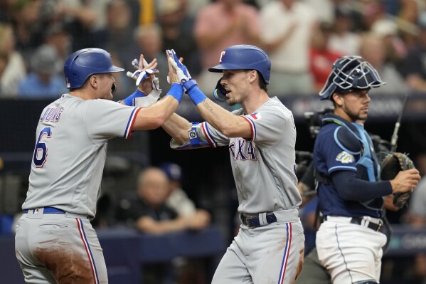Texas Rangers' Josh Jung (6) congratulates Evan Carter after Carter hit a home run scoring Jung in the fourth inning of Game 2 in an AL wild-card baseball playoff series against the Tampa Bay Rays, Wednesday, Oct. 4, 2023, in St. Petersburg, Fla. (AP Photo/John Raoux)