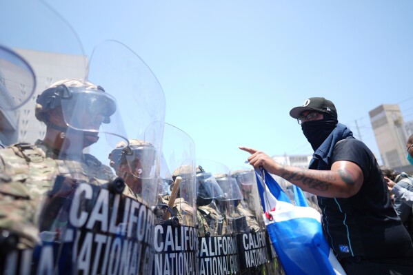 Un manifestante se enfrenta a una línea de la Guardia Nacional de EE. UU. en el centro de detención metropolitano del centro de Los Ángeles, el domingo 8 de junio de 2025, tras la protesta contra la redada migratoria de anoche. (Foto AP/Eric Thayer)