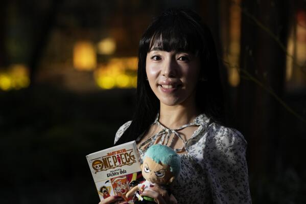 Nina Oiki, a gender and politics researcher at Tokyo's Waseda University, poses for a photo with some of her favorite "One Piece" anime character goods in Tokyo, Sunday, March 5, 2023. Oiki has been a "One Piece" fan since she was in elementary school. Hit Japanese manga “One Piece” is coming to Netflix as a live-action series, a development that's both exciting and worrisome for fans who have seen mixed success in a growing list of Hollywood adaptations. (AP Photo/Hiro Komae)