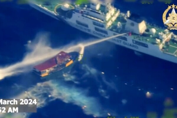 In this screen grab from video provided by the Armed Forces of the Philippines, a Chinese coast guard ship uses water cannons on a Philippine resupply vessel Unaizah May 4 as it approaches Second Thomas Shoal, locally called Ayungin shoal, at the disputed South China Sea on Saturday, March 23, 2024. (Armed Forces of the Philippines via AP)