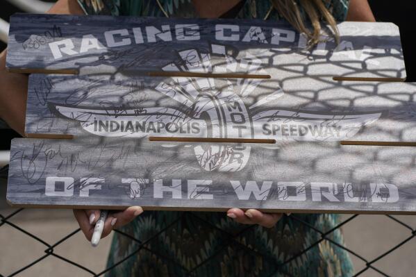 Kirstin Kendall holds a sign as she seeks autographs during practice for the Indianapolis 500 auto race at Indianapolis Motor Speedway, Monday, May 23, 2022, in Indianapolis. (AP Photo/Darron Cummings)