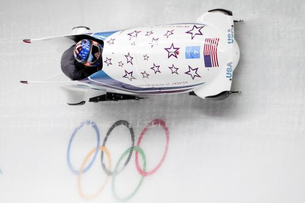 Kaillie Humphries and Kaysha Love, of the United States, slide during the women's bobsleigh heat 1 at the 2022 Winter Olympics, Friday, Feb. 18, 2022, in the Yanqing district of Beijing. (AP Photo/Dmitri Lovetsky)