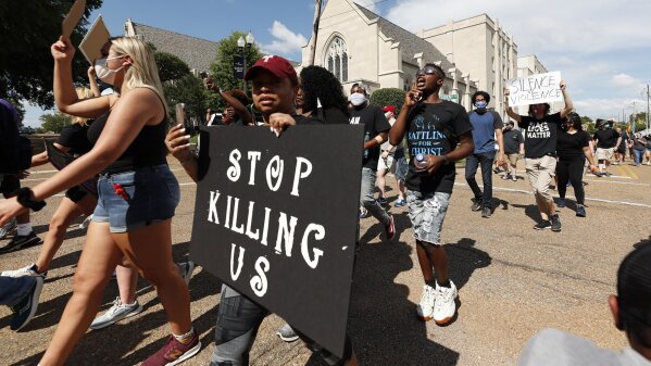 Hundreds of protesters march through downtown Jackson, Miss., in response to the recent death of George Floyd, and to highlight police brutality nationwide including Mississippi, Saturday, June 6, 2020. The Mississippi branch of Black Lives Matter held the rally and march and also encouraged the almost 1,000 participants to push leaders to seek long term solutions to issues plaguing the African American community. (AP Photo/Rogelio V. Solis)