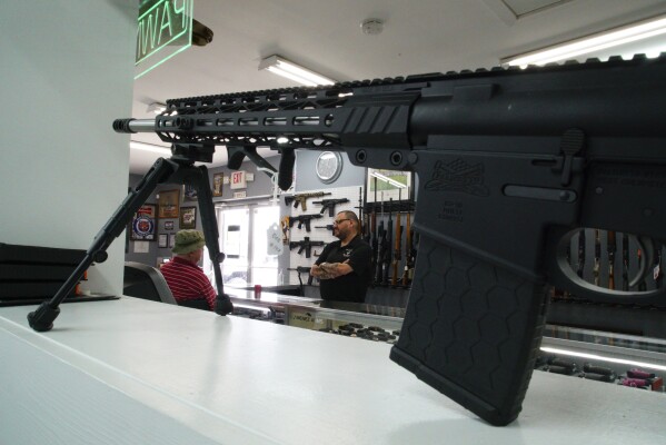 Ralph Rodriguez, right, chats with Army veteran Sidney High at his Fayetteville, N.C., pawn shop, Friday, May 9, 2025. (AP Photo/Allen G. Breed)