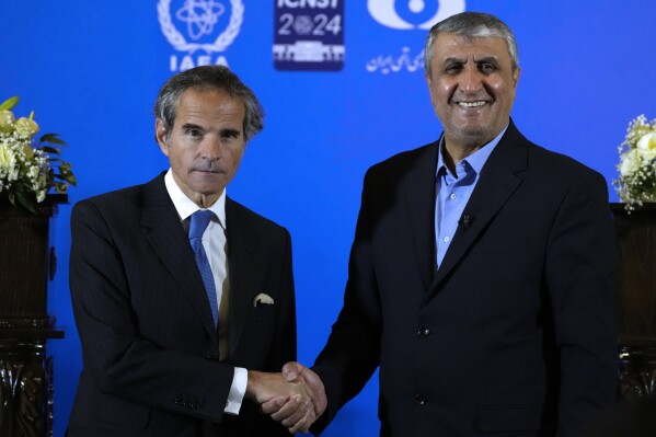 International Atomic Energy Organization, IAEA, Director General Rafael Grossi, left, and head of Iran's atomic energy department Mohammad Eslami shake hands at the conclusion of their joint press conference after their meeting in the central city of Isfahan, Iran, Tuesday, May 7, 2024. (AP Photo/Vahid Salemi)