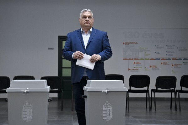 Hungarian Prime Minister Viktor Orban, leader of the ruling Fidesz party prepares to cast his vote at a polling station during the European Parliament and the local elections in Budapest, Hungary, Sunday June 9, 2024. (Szilard Koszticsak/MTI via AP)