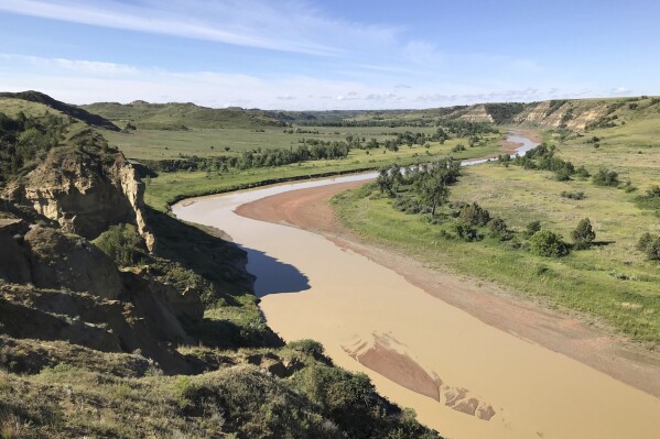 The Little Missouri River passes by Wind Canyon in Theodore Roosevelt National Park near Medora, N.D., on Wednesday, June 19, 2024. (AP Photo/Jack Dura)