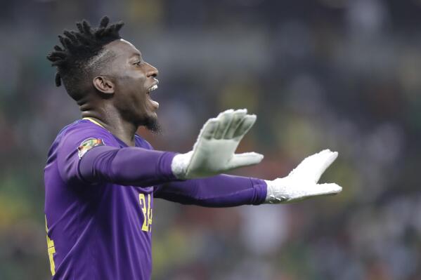 FILE - Cameroon's goalkeeper Andre Onana gestures during the African Cup of Nations 2022 quarter-final soccer match between Gambia and Cameroon at the Japoma Stadium in Douala, Cameroon, on Jan. 29, 2022. Cameroon goalkeeper André Onana escaped unhurt after being involved in a serious car crash on Tuesday, March 22, 2022 while traveling to the team camp ahead of a decisive World Cup playoff, the national soccer federation said. The crash happened while Onana, who plays for Dutch club Ajax, was traveling from the Cameroon capital Yaounde to the city of Douala. (AP Photo/Sunday Alamba, File)