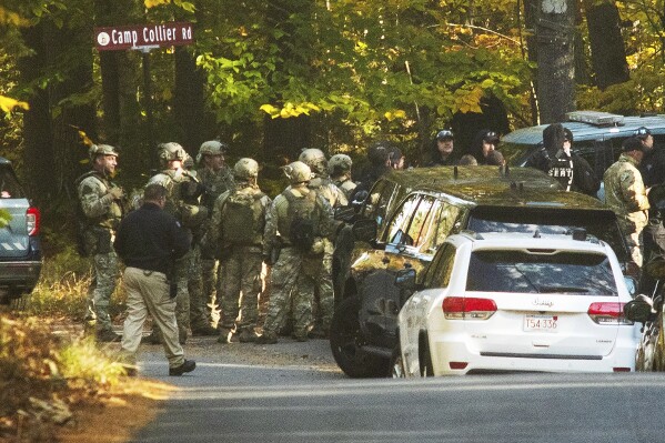 Massachusestts State Police troopers gather Tuesday, Oct. 24, 2023, at the intersection of Kelton St. and Camp Collier Road in Gardner, Mass., during a search for Aaron Pennington. Law enforcement officials are searching for Pennington, who is wanted for questioning in connection with the shooting death of his 30-year-old wife, Breanne Pennington, who was found in their home on Sunday. (Rick Cinclair/Worcester Telegram & Gazette via AP)
