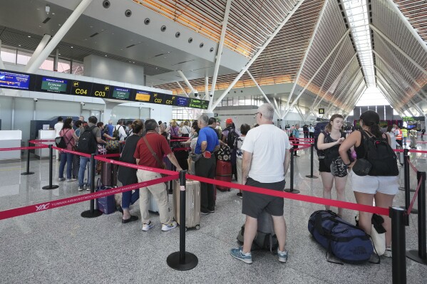 Toeristen staan ​​in de rij om in te checken voor vertrek op de Siem Reap International Airport in de provincie Siem Reap, Cambodja, wanneer deze op donderdag 16 november 2023 wordt geopend. De nieuwe luchthaven biedt plaats aan 7 miljoen passagiers per jaar en is van plan dit met 12 te verhogen. miljoen passagiers per jaar vanaf 2040. Het werd gebouwd als onderdeel van een 55 jaar durend build-operate-transfer (BOT) programma tussen Cambodja en China.  (AP-foto/Heng Sinith)