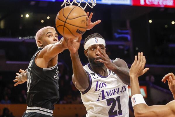 Los Angeles Lakers guard Patrick Beverley, right, passes the ball while defended by San Antonio Spurs forward Jeremy Sochan during the first half of an NBA basketball game Sunday, Nov. 20, 2022 in Los Angeles. (AP Photo/Ringo H.W. Chiu)