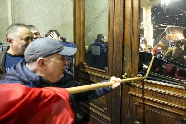Opposition supporters attempt to enter the capital's city council building in protest of what election observers said were widespread vote irregularities during a general election last weekend in Belgrade, Serbia, Sunday, Dec. 24, 2023. The country's populist authorities have denied rigging the vote. President Aleksandar Vucic said Sunday that those claims were blatant 