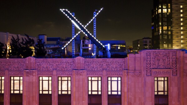 Workers install lighting on an "X" sign atop the company headquarters, formerly known as Twitter, in downtown San Francisco, on Friday, July 28, 2023. (AP Photo/Noah Berger, File)
