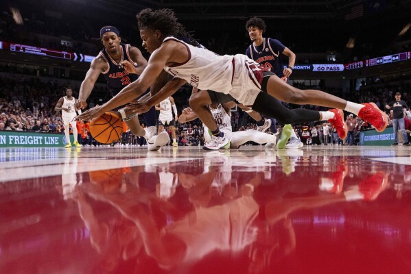 South Carolina forward Nick Pringle (5) and Auburn guard Denver Jones (2) dive for a loose ball during the second half of an NCAA college basketball game on Saturday, Jan. 11, 2025, in Columbia, S.C. (AP Photo/Scott Kinser)