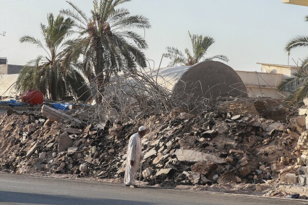 A man walks past the rubble of a demolished al-Siraji Mosque in Basra, Iraq, on Monday, July 17, 2023. An official said the old mosque would be replaced with a modern, better-designed one that would not impede traffic flow. (AP Photo/Nabil al-Jurani)