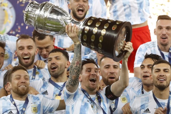 FILE - Argentina's Lionel Messi holds the trophy as he celebrates with the team after beating 1-0 Brazil in the Copa America final soccer match at the Maracana stadium in Rio de Janeiro, Brazil, Saturday, July 10, 2021. Argentina is the favorite to repeat in the Copa America (AP Photo/Andre Penner, File)