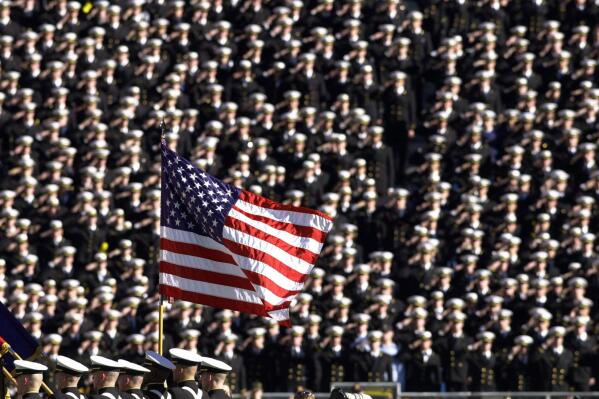 FILE - In this Dec. 1, 2001, file photo, the American flag flies with a background of Navy midshipmen during the national anthem at the 102nd Army Navy NCAA college football game in Philadelphia. Twenty years later, former Army football coach Todd Berry still gets choked up thinking about that Sept. 11, 2001, day and the terrorist attacks carried out not only on the twin towers at the World Trade Center but at the Pentagon, and in a field in rural Pennsylvania. (AP Photo/Chris Gardner, File)