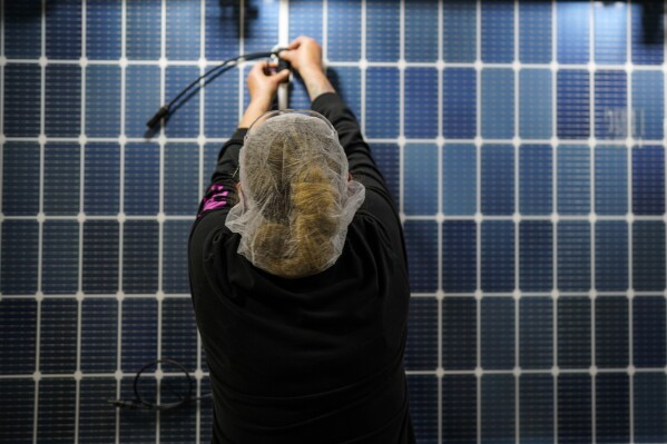 File - An employee works on a solar panel inside the Hanwha Qcells Solar plant on Oct. 16, 2023, in Dalton, Ga. On Wednesday, the Labor Department reports on job openings and labor turnover for September. (AP Photo/Mike Stewart, File)