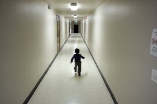 FILE - In this Dec. 11, 2018 file photo, an asylum-seeking boy from Central America runs down a hallway after arriving from an immigration detention center to a shelter in San Diego. The American Civil Liberties Union says on Thursday, Oct. 24, 2019, U.S. immigration authorities separated more than 1,500 children from their parents at the Mexico border early in the Trump administration, bringing the total number of children separated since July 2017 to more than 5,400. (AP Photo/Gregory Bull, File)